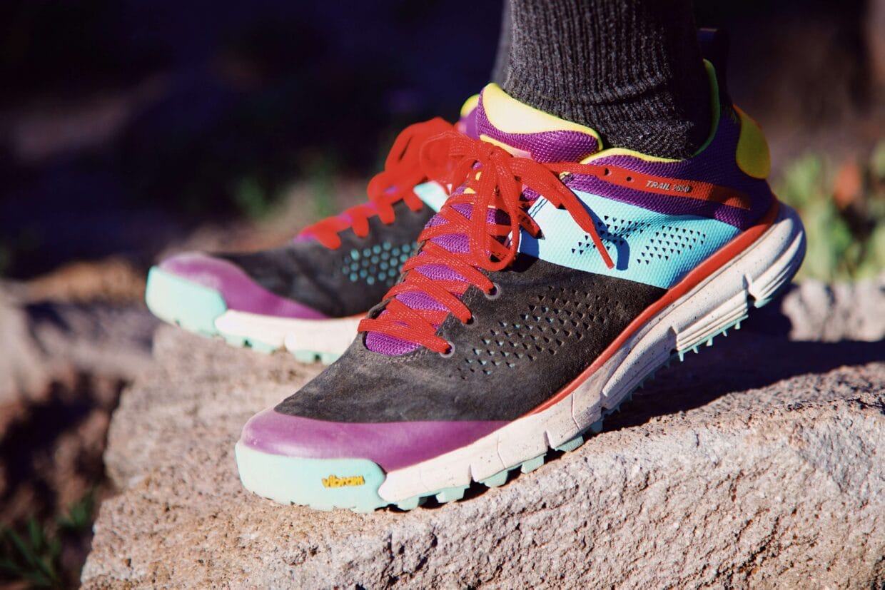 Diferentes modelos de tênis para trail running com solas variadas em terreno de trilha