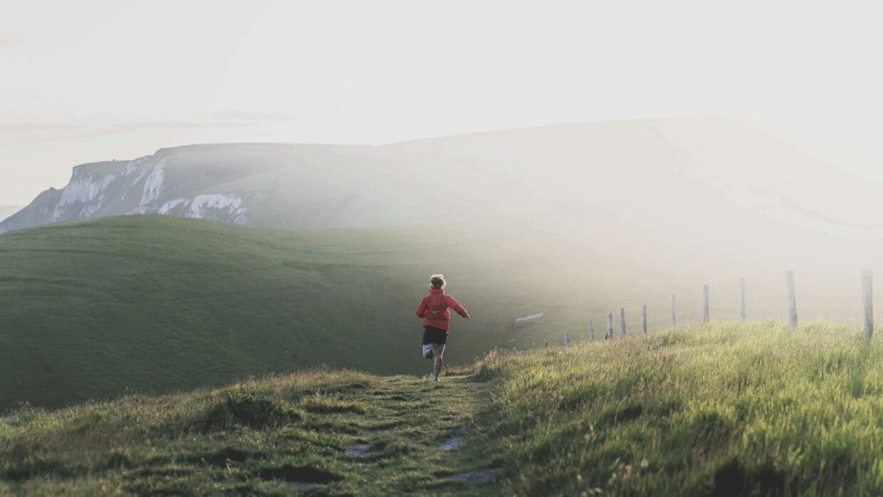 Corredor em sua primeira trilha de trail running em caminho de terra com vegetação ao redor