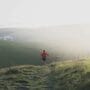 Corredor em sua primeira trilha de trail running em caminho de terra com vegetação ao redor