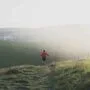 Primeira trilha de trail running: o que ninguém te conta antes de sair 5 Corredor em sua primeira trilha de trail running em caminho de terra com vegetação ao redor
