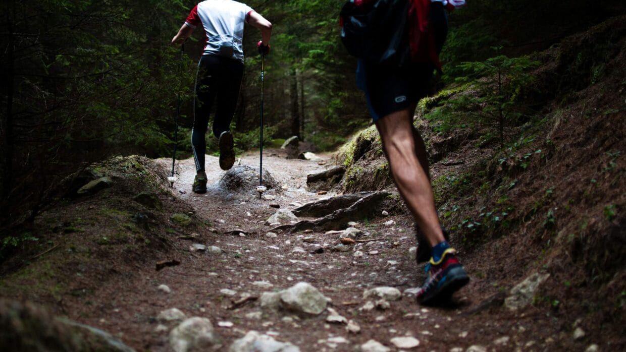 O que é trail running: guia completo para começar 10 Corredor em trilha de terra com vegetação nativa ao fundo durante treino de trail running