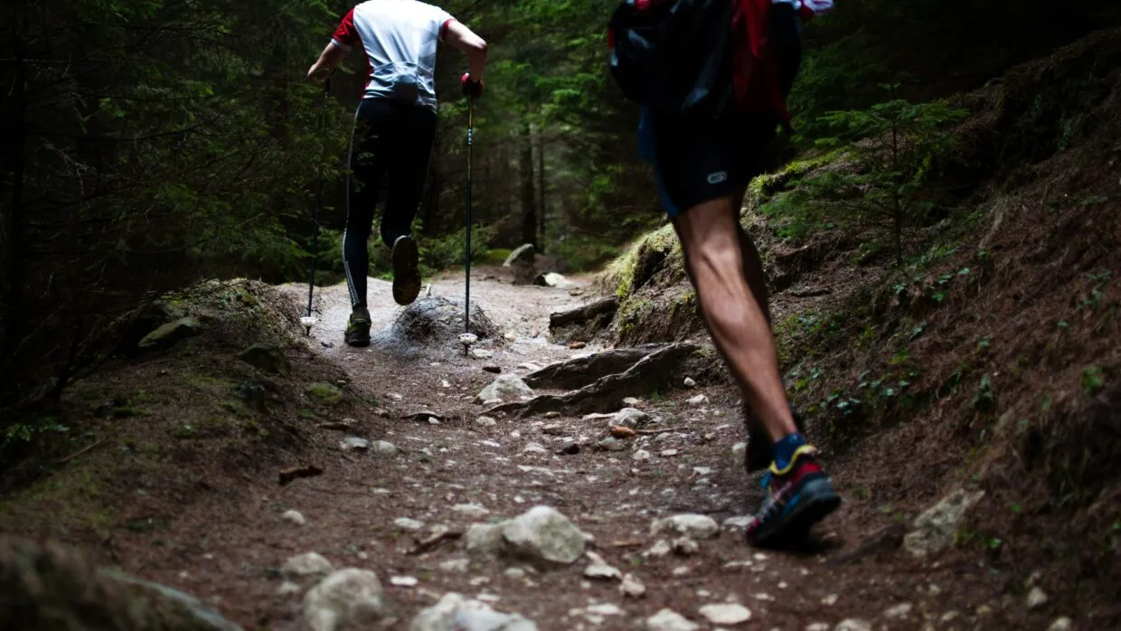 O que é trail running: guia completo para começar 10 Corredor em trilha de terra com vegetação nativa ao fundo durante treino de trail running