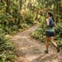 Zona 2 no trail corredora em ritmo leve em trilha de floresta com frequência cardíaca baixa e base aeróbica em construção
