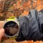 Corredor usando Garmin Fenix 8 Solar no pulso durante prova de trail running em montanha