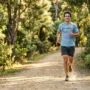Como começar no trail running: guia completo para iniciantes 6 Iniciante trail running grupo em trilha técnica com raízes e pedras aprendendo técnica de descida e posicionamento do pé na floresta