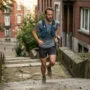 Como treinar trail sem trilha próxima: o que a ciência diz 5 Treinar trail sem trilha corredor subindo escadaria urbana com colete e tênis de trail mostrando técnica de subida e esforço excêntrico na cidade