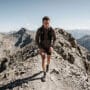 Skyrunner subindo crista técnica íngreme em terreno rochoso com corrida de montanha e desnível extremo
