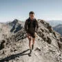 Skyrunner subindo crista técnica íngreme em terreno rochoso com corrida de montanha e desnível extremo