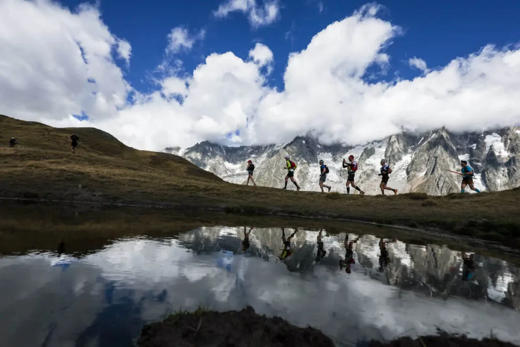 UTMB: a prova que todo trail runner sonha correr 11 corredores em crista alpina com Mont Blanc nevado ao fundo no UTMB