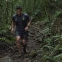 Como se preparar para uma ultramaratona: corredor em trilha de Mata Atlântica com mochila de hidratação e lama nas pernas