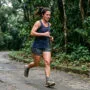 por que começar a correr é difícil: mulher em treino com expressão de esforço real em parque urbano ao amanhecer